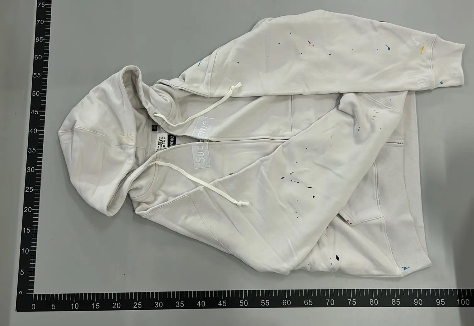 White zip hoodie with paint-style specks beside a measurement ruler, from the Boonbuy post by Reddit user SubjectVillage7149