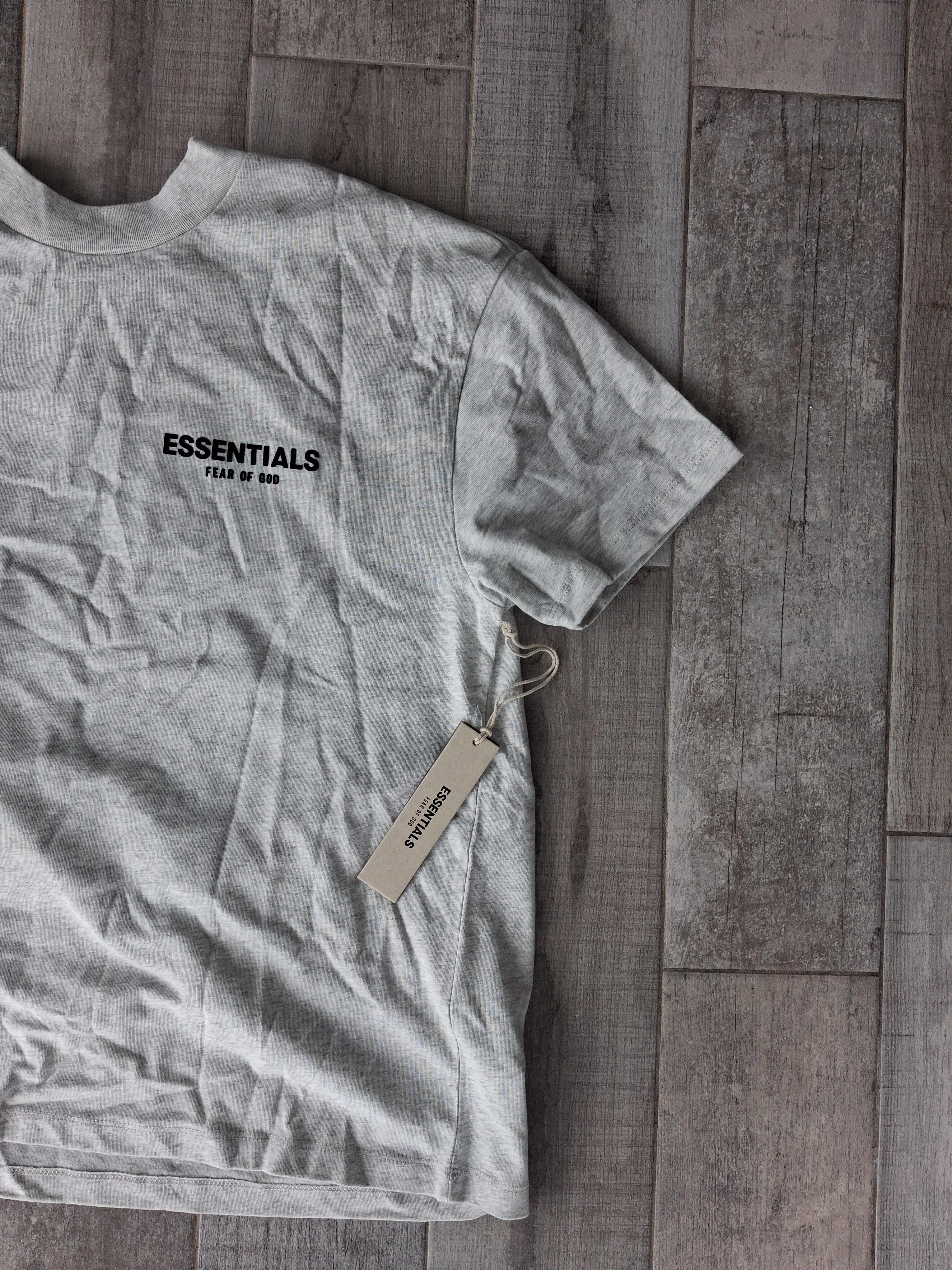 Grey Essentials T-shirt on a wooden floor, from the Boonbuy post by Reddit user Regular-Divide584