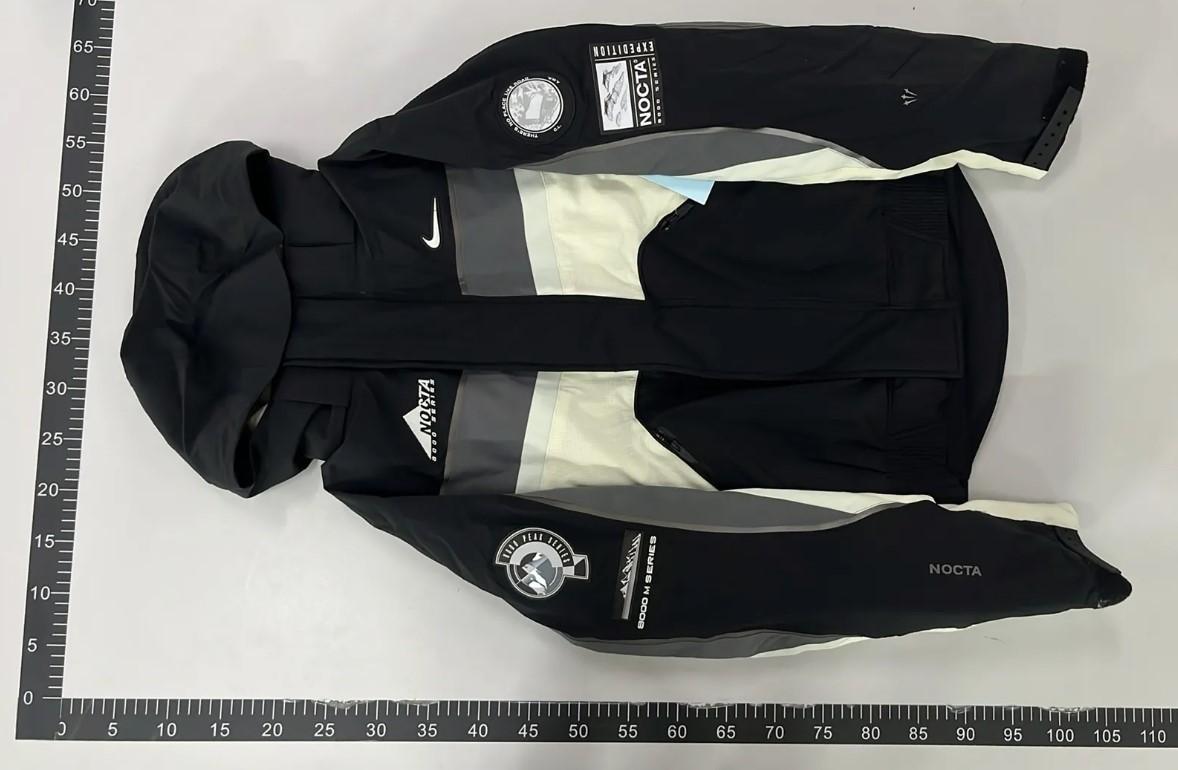 Warehouse QC photo of a black and cream jacket beside a measurement ruler, posted by Reddit user C0soo